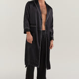 Man wearing open-front Jasmisilk men's black pure silk robe with white piping, paired with matching silk pants