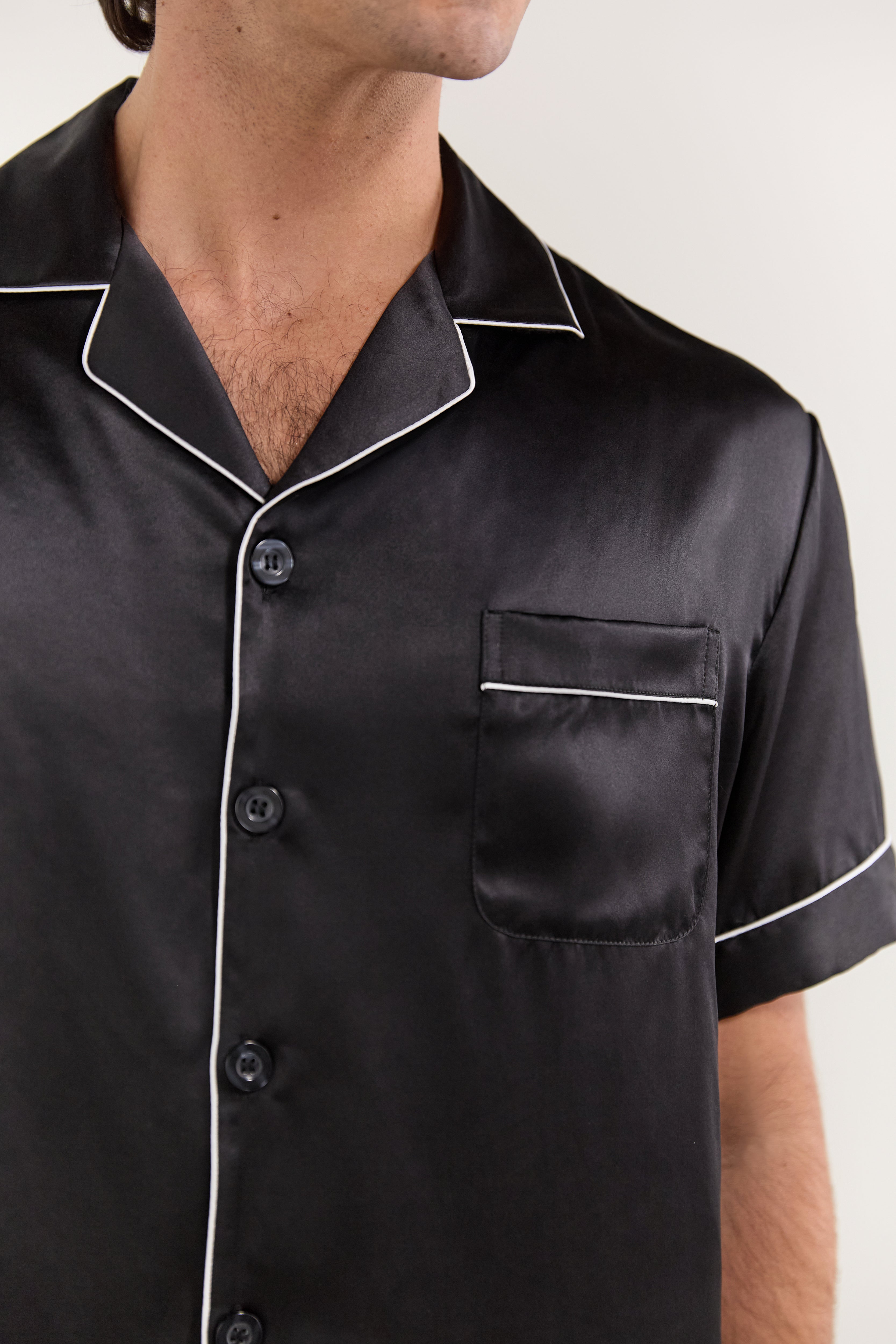 Close-up of collar, buttons, and chest pocket on Jasmisilk men's black silk pajama