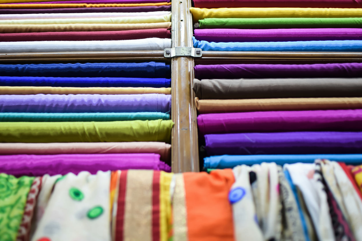 Shelves filled with vibrant silk fabrics, highlighting different types of silk for elegant sleepwear.